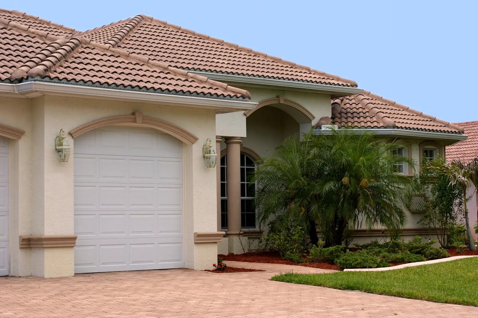 Single-story stucco home with a clay tile roof and attached garage.