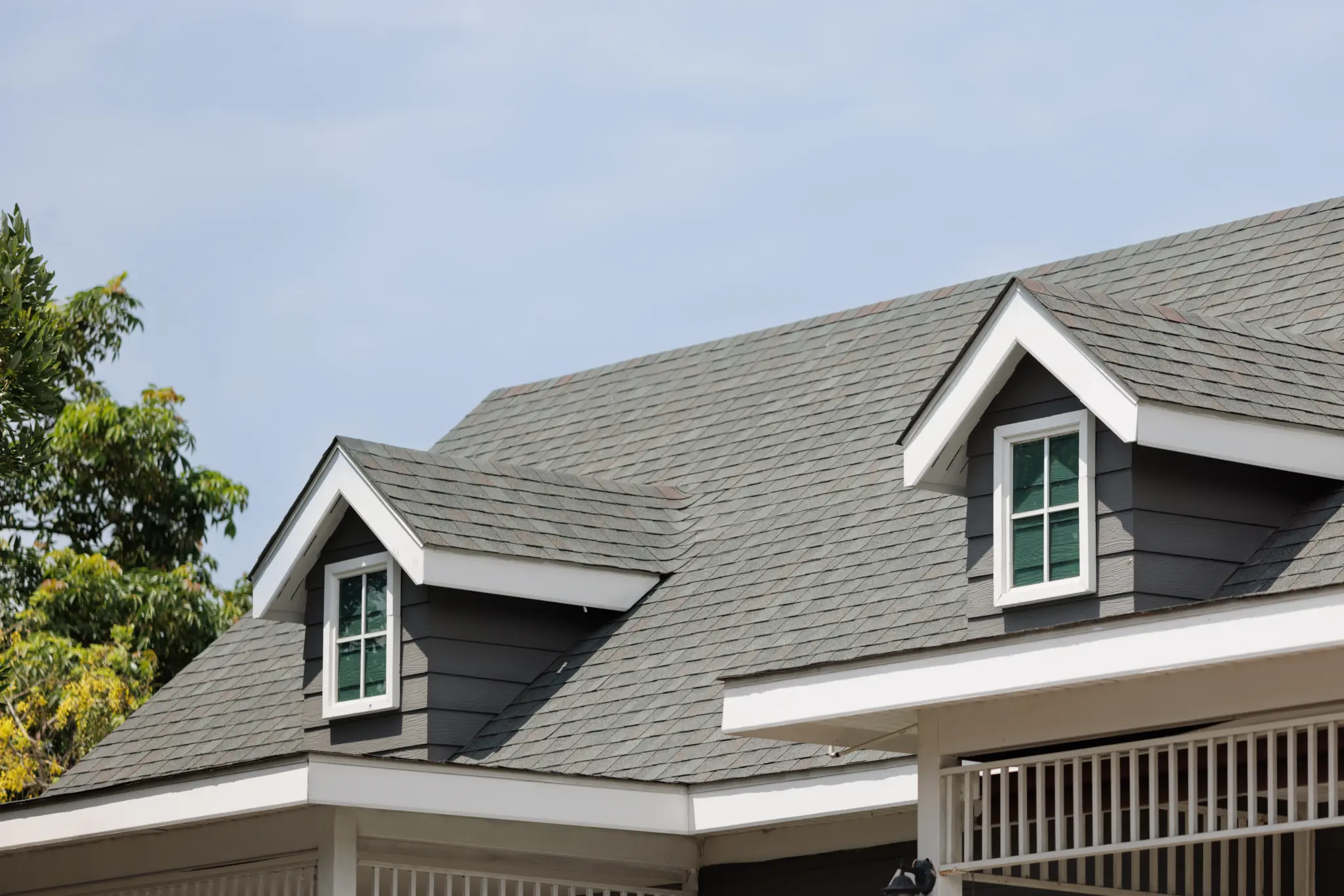 Gray asphalt shingle roof with dormer windows on a residential home.