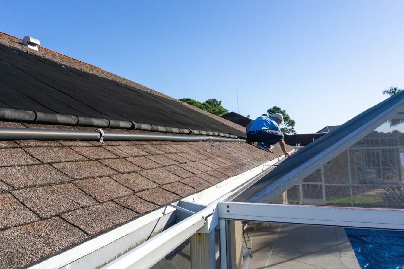 Roofer inspecting an asphalt shingle roof on a residential home.